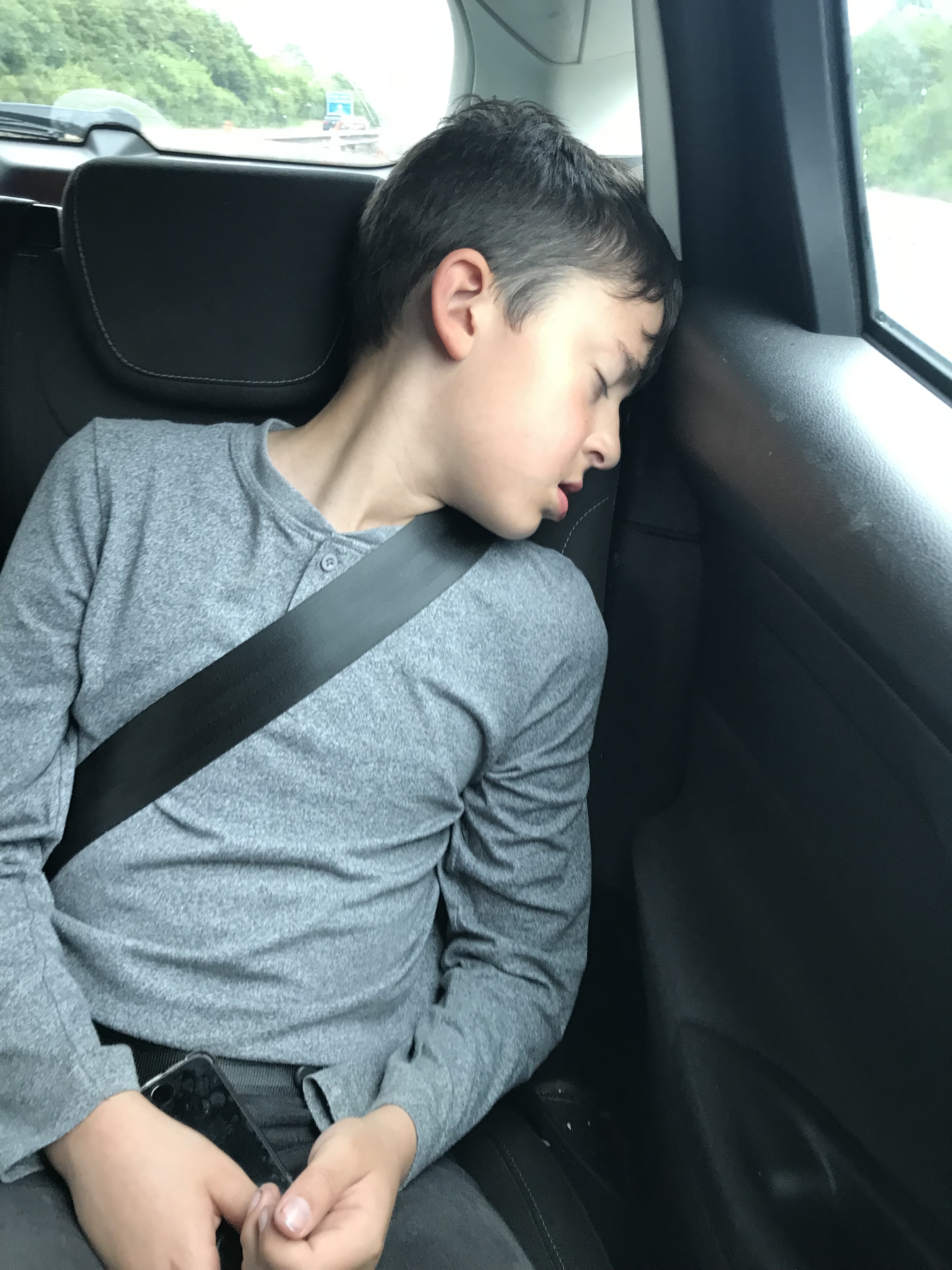 Child wearing grey while sleeping in a car