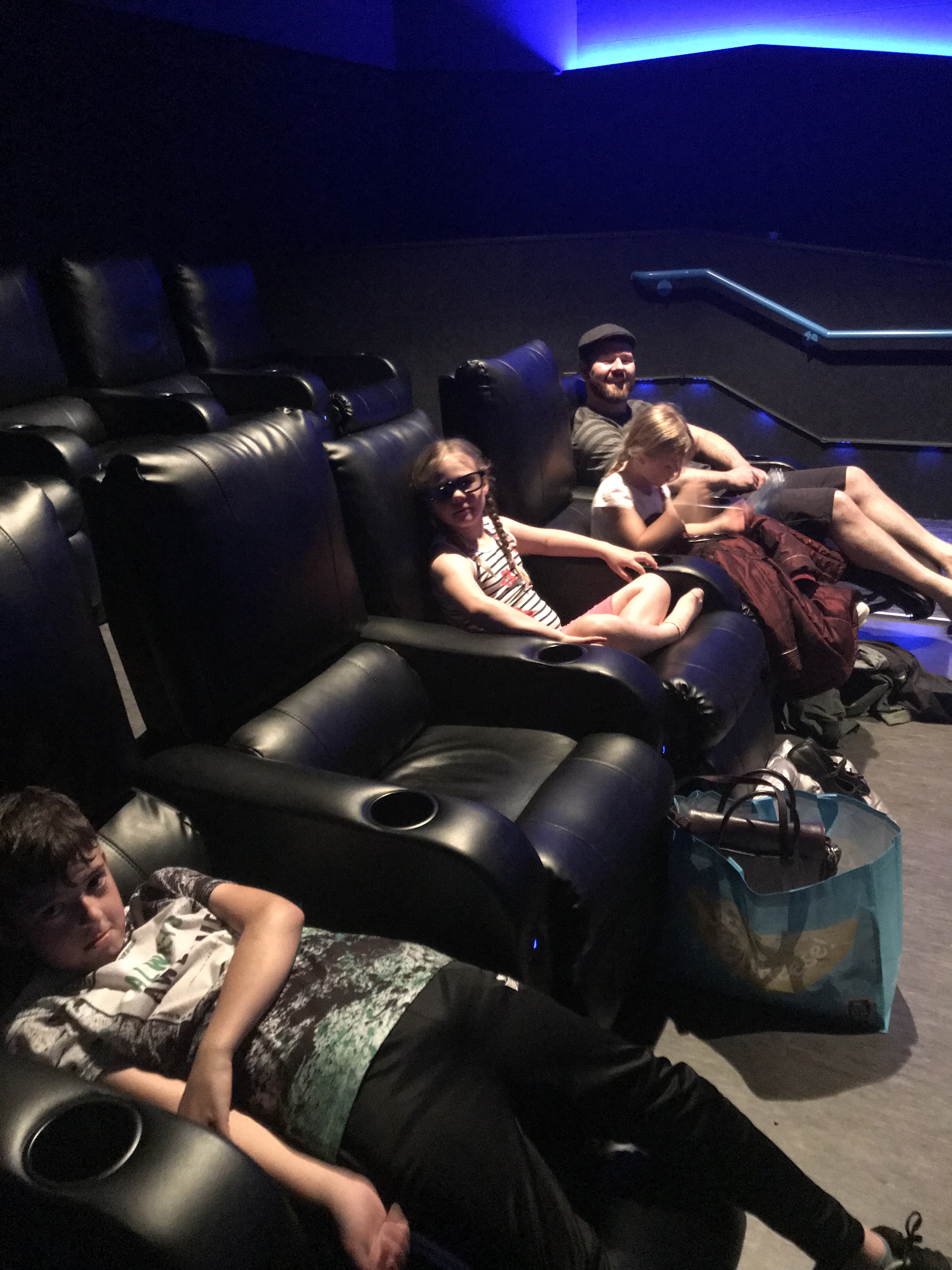 5 Deluxe cinema seats with 3 children and one adult sitting in them