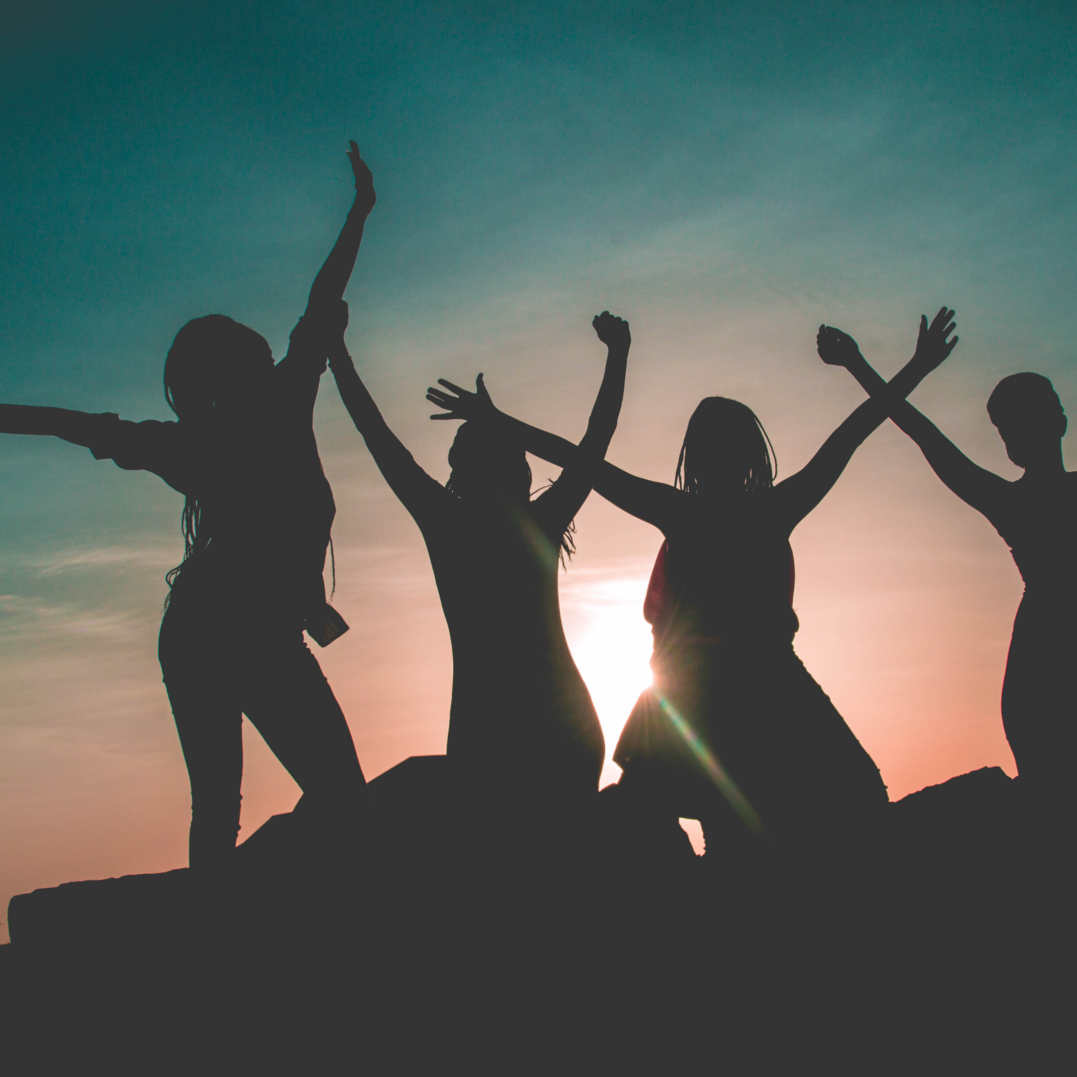 Silhouettes jumping in the air at sunset 