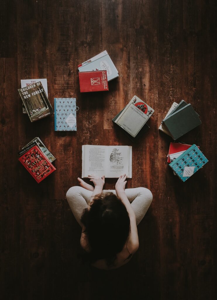 Child reading with piles of books