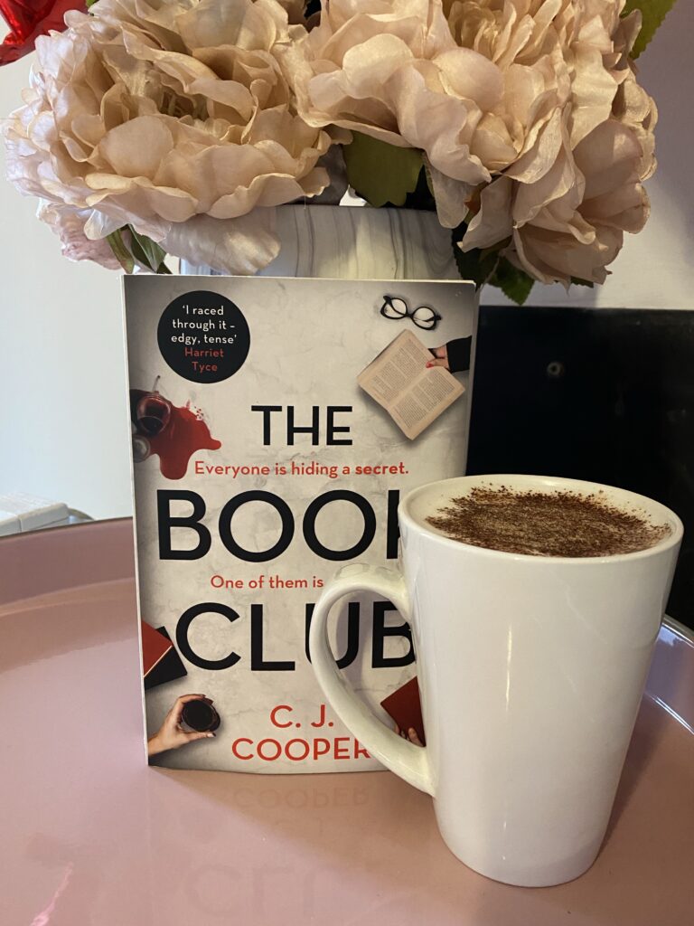 A book with vase of flowers and a coffee