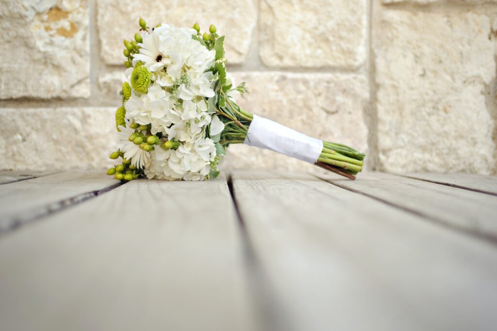 Bouquet lying on a wooden floor with brick wall behind