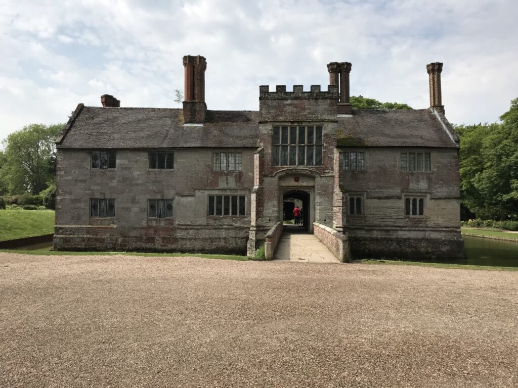 Historic building, Baddesley Clinton, surrounded by a moat on a sunny day