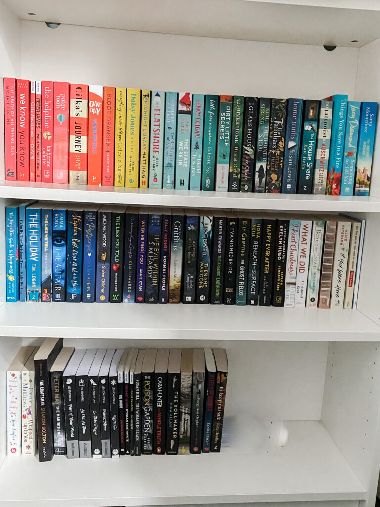White bookshelf with books in rainbow order
